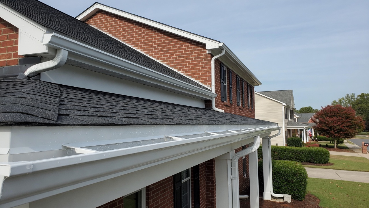 Before and after professional gutter cleaning on a Norfolk VA home - sparkling clean gutters and downspouts